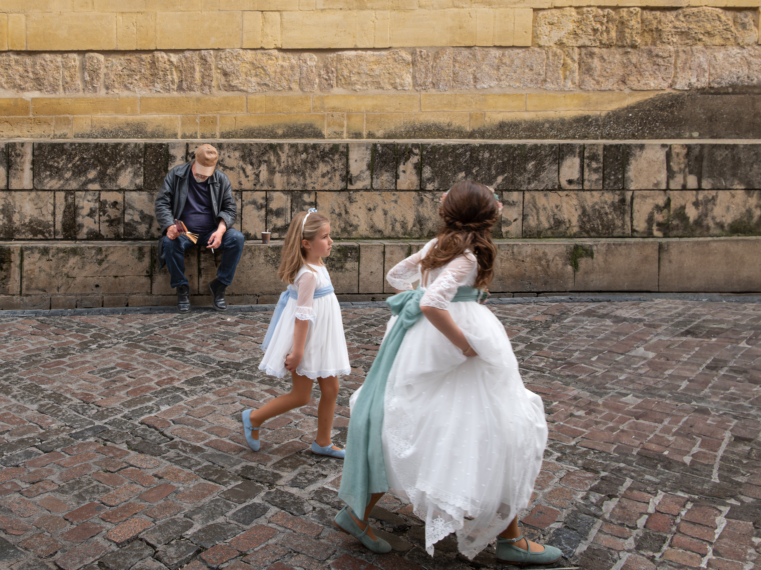 Mädchen in weißen Kommunionskleidern am Pflaster der Altstadt